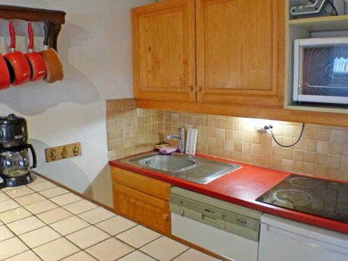 une cuisine avec un évier et un micro-ondes dans l'établissement 2 pièces cabine lumineux, proche centre Samoëns, animaux acceptés, parking, balcon - FR-1-629-22, à Samoëns