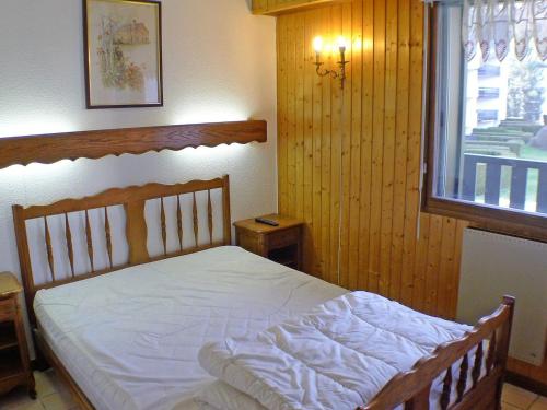 une chambre avec un lit blanc avec une fenêtre dans l'établissement 2 pièces cabine lumineux, proche centre Samoëns, animaux acceptés, parking, balcon - FR-1-629-22, à Samoëns