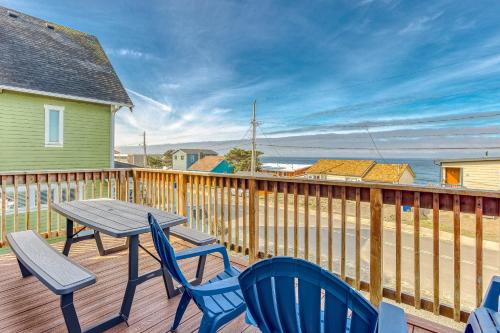 a wooden deck with a table and chairs on it at A Slice Above in Lincoln City