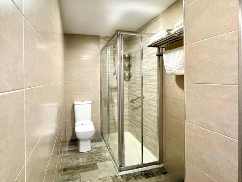 a bathroom with a toilet and a glass shower at Modern apartment in Benalmádena with garden in Benalmádena