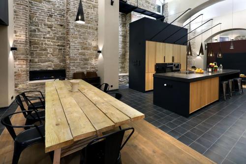eine Küche und ein Esszimmer mit einem Holztisch in der Unterkunft American Loft in the Heart of Prague in Prag