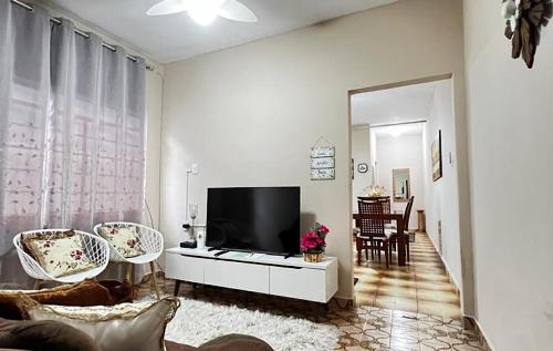 a living room with a flat screen tv and chairs at Divino Espírito Santo in Aparecida