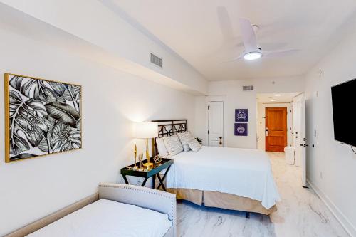 a white bedroom with a bed and a tv at Baytowne Wharf - Market Street Inn #336 in Destin