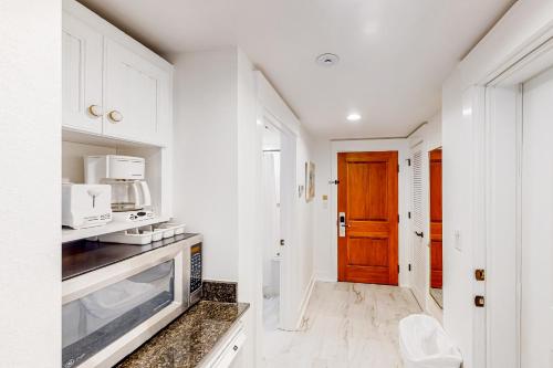 a kitchen with white cabinets and a wooden door at Baytowne Wharf - Market Street Inn #336 in Destin