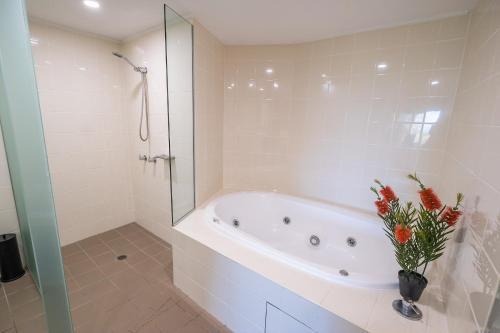 a white bathroom with a tub and a glass shower at Pavillions on 1770 in Agnes Water