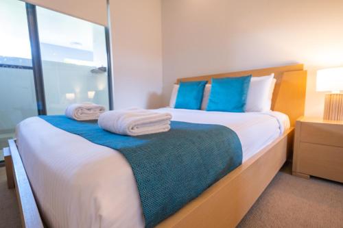 a bedroom with a large bed with towels on it at Pavillions on 1770 in Agnes Water