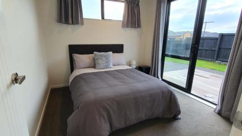 a bedroom with a bed and a large window at Cozy 2- Bedrooms Unit In Hamilton in Hamilton