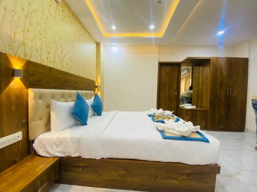 a bedroom with a large white bed with blue pillows at Spectra Hotel Bangalore Airport in Bangalore