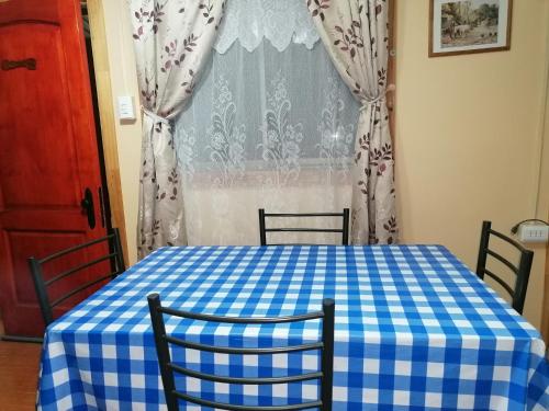 a blue and white checkered table and chairs in front of a window at Cabaña "Descanso playero" in Quintero