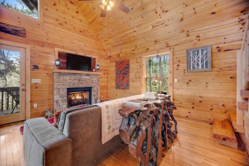 a living room with a fireplace in a log cabin at Sylva Serenity in Sylva
