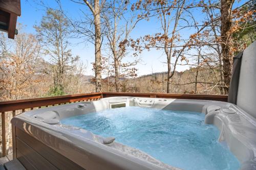a jacuzzi tub on a deck with trees at Sylva Serenity in Sylva