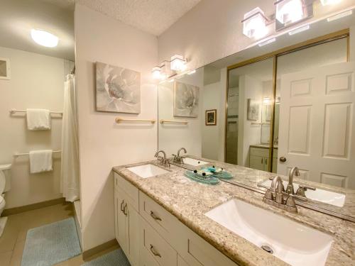 een badkamer met 2 wastafels en een grote spiegel bij Hale Kamaole 271 in Wailea