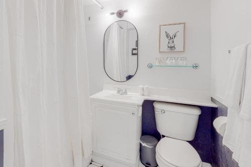 a white bathroom with a toilet and a mirror at Enchanting Elektra #702 in Seattle