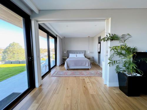 1 dormitorio con 1 cama y ventanas grandes en Balgowlah Paradise Apartment en Sídney