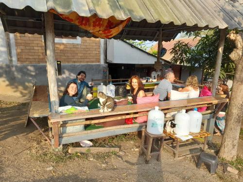 a group of people sitting at a picnic table at KK Hut in Pai