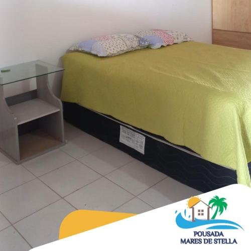 1 dormitorio con cama y mesa de cristal en Pousada Mares de Stella, en Salvador