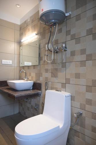 a bathroom with a toilet and a sink at Hotel Apple Blossom B$B in Manāli