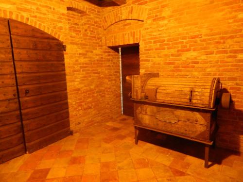 CortemiliaにあるCastel Martinoのレンガの壁にベッドが備わる部屋