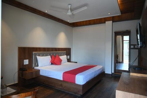 a bedroom with a bed and a television in it at Hotel Apple Blossom B$B in Manāli