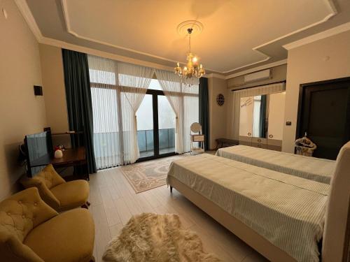 um quarto com uma cama, um sofá e uma televisão em Çolakoğlu Konağı em Rize