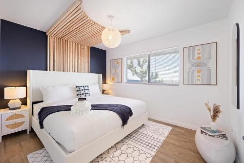 una camera da letto con un letto bianco e una finestra di Mojave Midnight Oasis a Joshua Tree