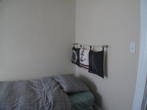 a bedroom with a bed and towels hanging on a wall at Wolseley the heart of the city ! in Winnipeg