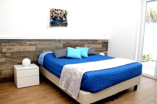 sypialnia z dużym łóżkiem z niebieskimi poduszkami w obiekcie Altomare Case Vacanza w mieście Torre Lapillo