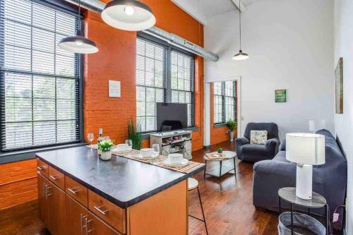 a living room with a couch and a table in a room at NY Style Centric Loft with King Bed by Park av. in Rochester