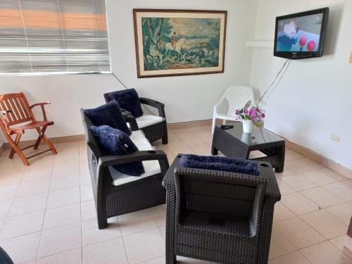 - un salon avec plusieurs chaises et une télévision dans l'établissement Apartamento central melgar, à Melgar
