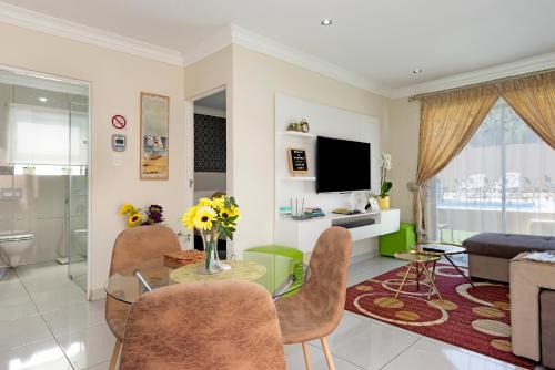 uma sala de estar com mesa e cadeiras em Marigold - No Load Shedding em Brackenfell