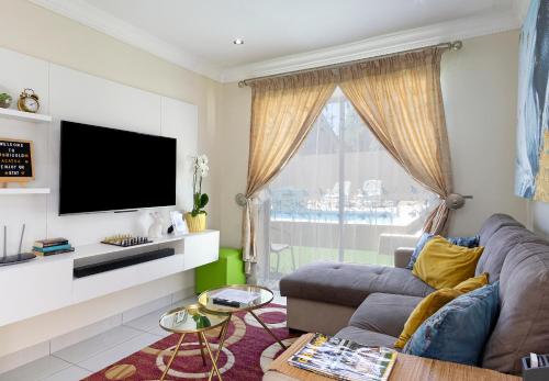 a living room with a couch and a flat screen tv at Marigold in Brackenfell