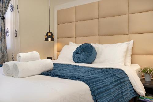 a bedroom with a large bed with a blue pillow at Marigold in Brackenfell