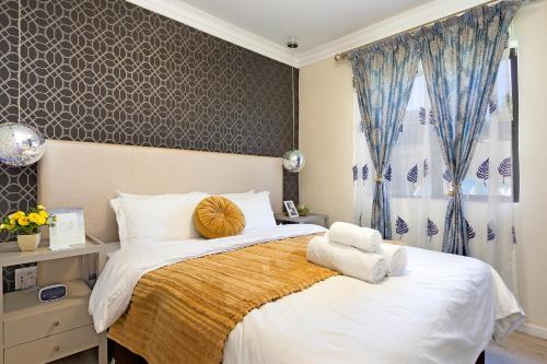 sypialnia z dużym łóżkiem z ręcznikami w obiekcie Marigold - No Load Shedding w mieście Brackenfell