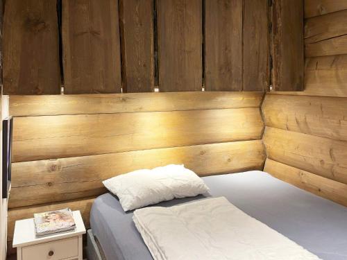 Holiday home Drangedal II في Drangedal: سرير في غرفة بجدار خشبي