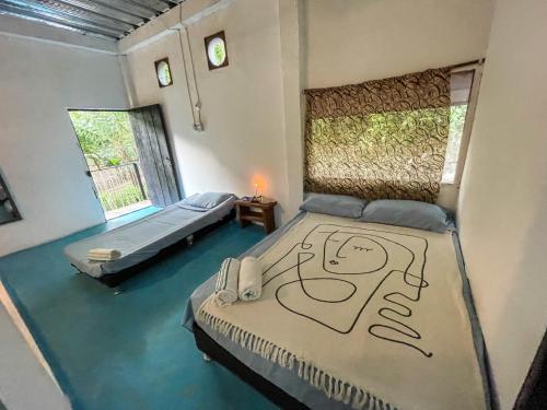a bedroom with two beds with a face drawn on it at Los Almendros Palomino Hostel in Palomino