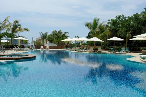 a large swimming pool with chairs and umbrellas at Azul Ixtapa Grand All Inclusive Suites - Spa & Convention Center in Ixtapa