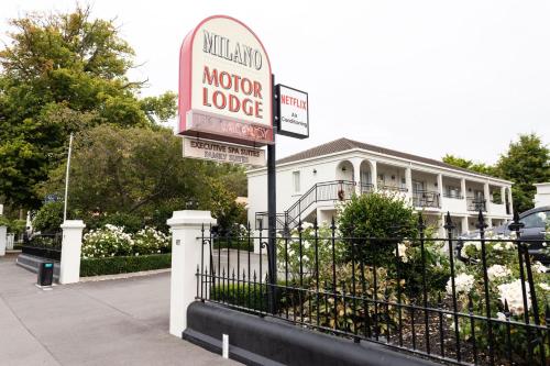 un cartel de la casa de motor frente a una casa en Milano Motor Lodge en Christchurch