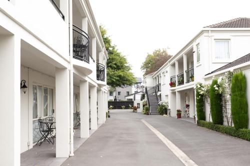 pusta aleja pomiędzy dwoma białymi budynkami w obiekcie Milano Motor Lodge w mieście Christchurch