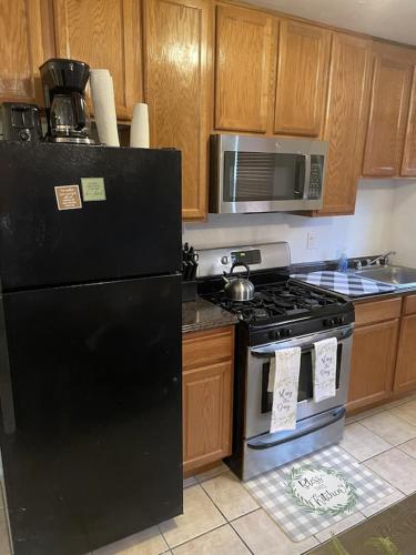 a kitchen with a black refrigerator and a stove at Cozy 2 Bedroom, Minutes from Capitol Hill in Washington