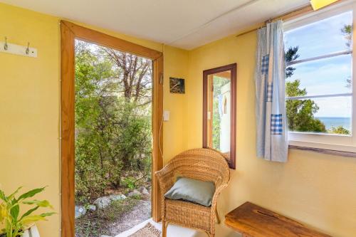 a wicker chair sitting in a room with a window at Ao Marama Retreat in Collingwood