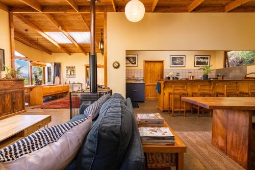 a living room with a couch and a kitchen at Ao Marama Retreat in Collingwood