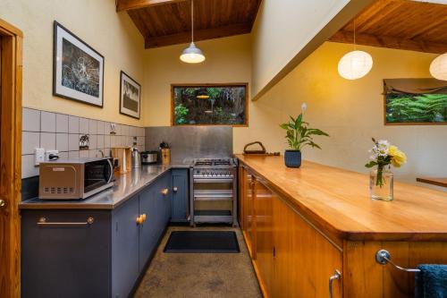 a kitchen with blue cabinets and a wooden counter top at Ao Marama Retreat in Collingwood