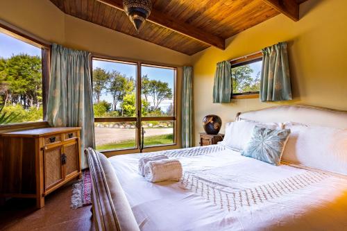 sypialnia z łóżkiem i dużym oknem w obiekcie Ao Marama Retreat w mieście Collingwood