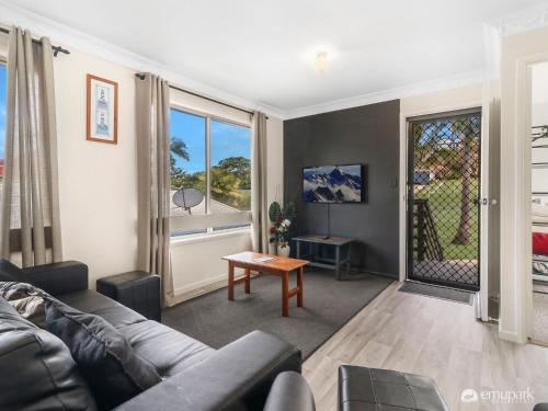 a living room with a couch and a table at Sea Breeze On Archer! in Emu Park