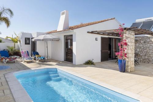 una villa con piscina di fronte a una casa di Villa Petala ad Albufeira