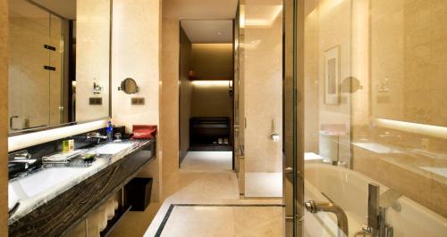 a bathroom with two sinks and a tub and a shower at Crowne Plaza Tianjin Jinnan, an IHG Hotel in Tianjin