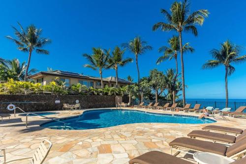 una piscina con sillas y palmeras en Polo Beach Club One Bedrooms by Coldwell Banker Island Vacations en Wailea