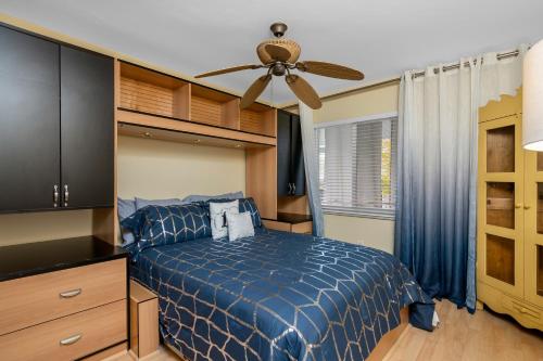 a bedroom with a blue bed and a ceiling fan at Hidden Gem 813 in Naples