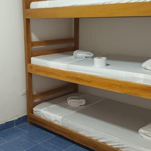 a bunk room with two bunk beds with white shelves at Girasoles Tolu in Santiago