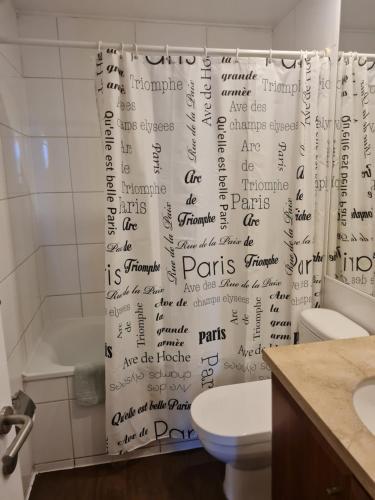 uma casa de banho com uma cortina de chuveiro com escrita em Departamentos Pontoni Manquehue em Santiago